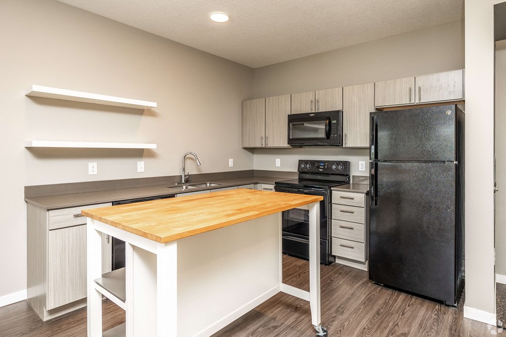 a kitchen with black appliances and a wooden counter top