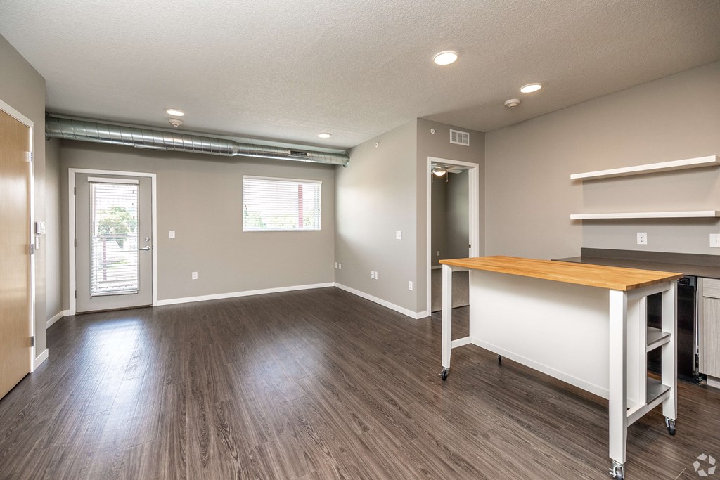 a view of a living room and a dining room with wood flooring