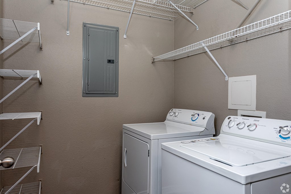 a laundry room with two washes and a dryer in it and a closet