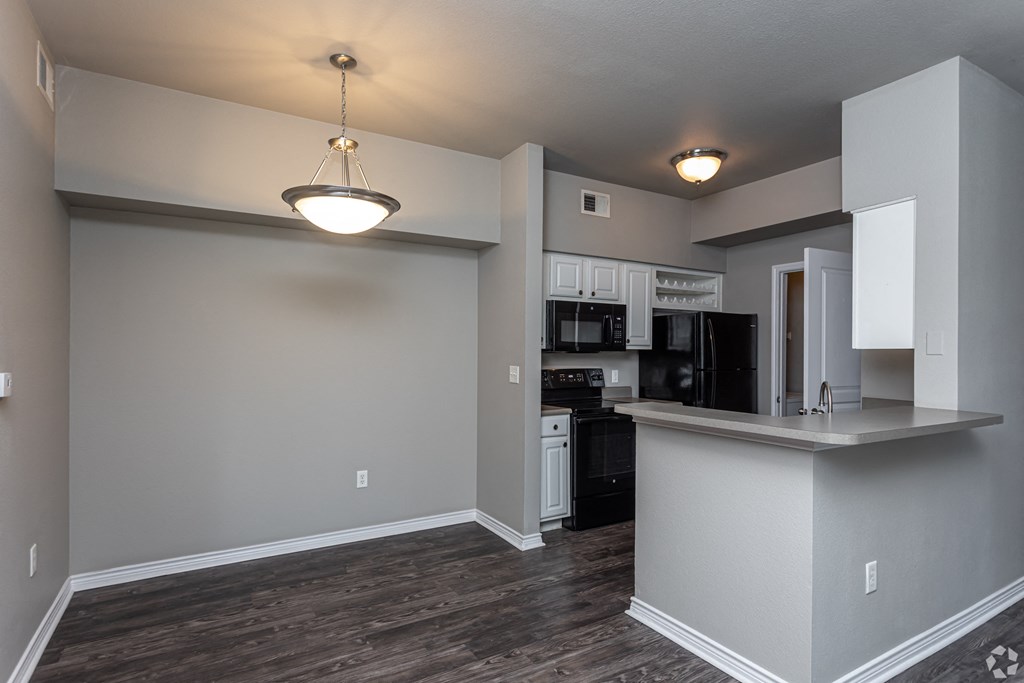 an empty living room and kitchen with a counter top and