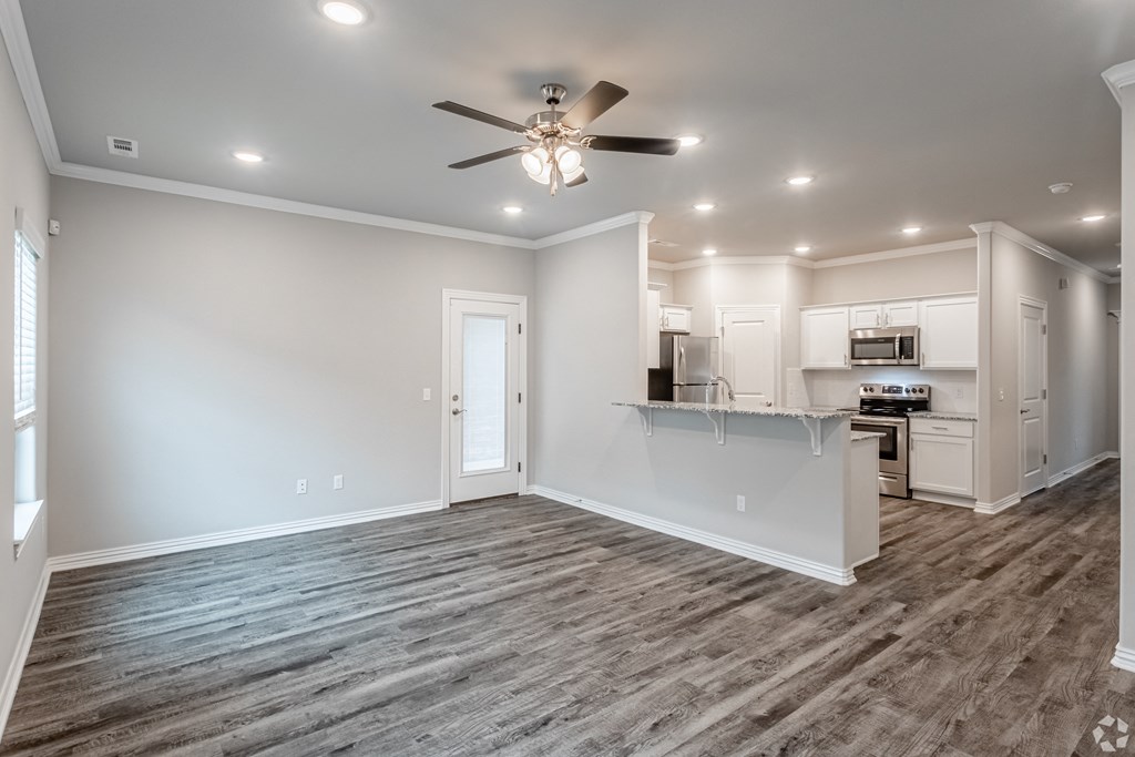 a living room with a kitchen in the background