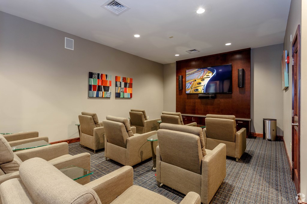 A room with a row of chairs and a television on the wall.