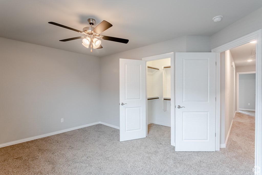 a bedroom with a ceiling fan and closet