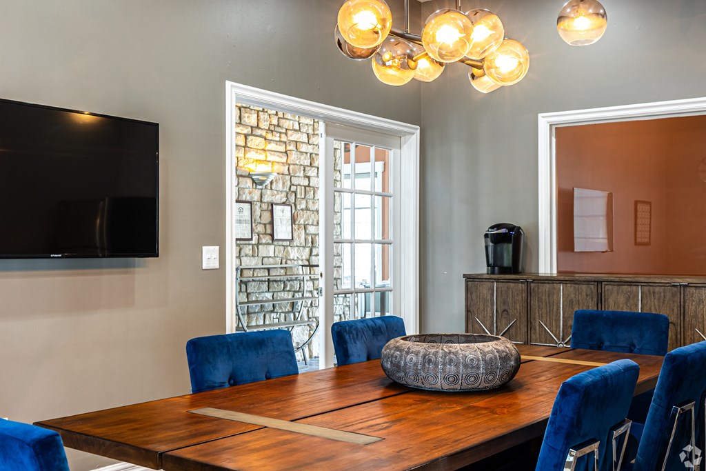 A dining room with a wooden table and blue chairs.