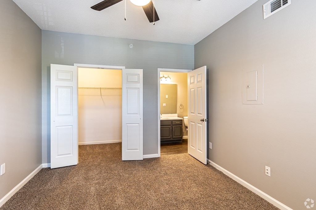 A room with a ceiling fan and a carpeted floor.