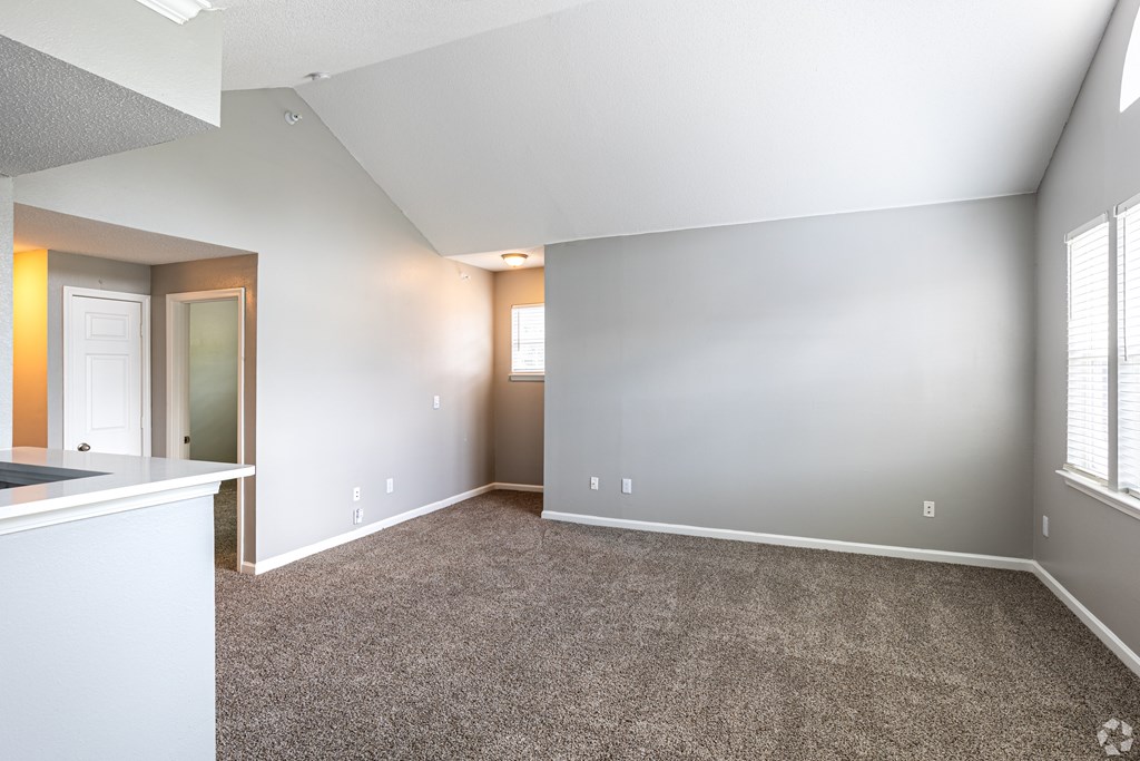 A spacious room with carpeted floor and white walls.