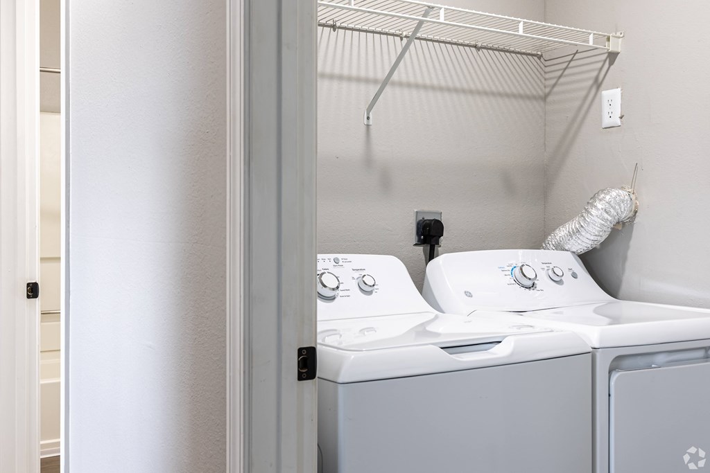 A white washing machine and dryer in a small laundry room.