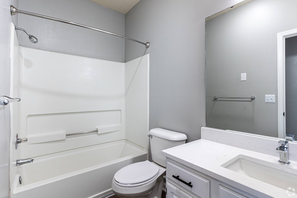 A white bathroom with a toilet, sink, and bathtub.