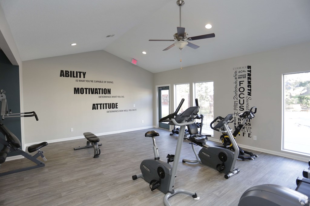 A gym with a wall that says "Ability", "Motivation", and "Attitude".
