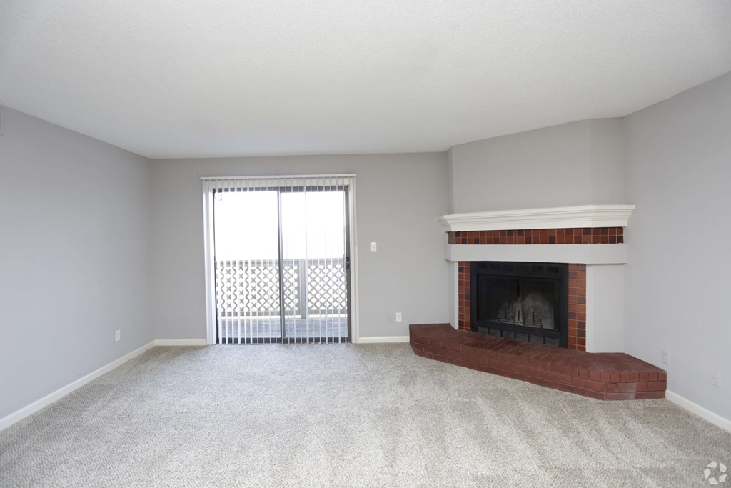A living room with a fireplace and sliding glass doors.