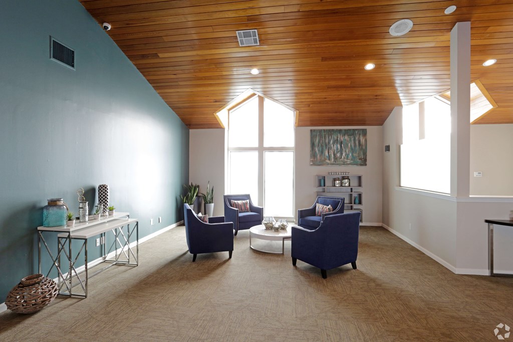 A living room with a wooden ceiling and a large window.