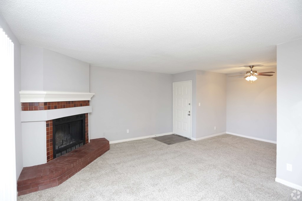 A room with a fireplace and a ceiling fan.