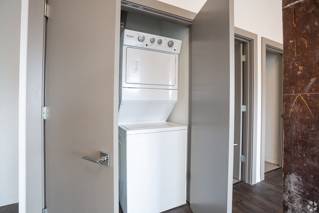 a white washer and dryer in a room with a door