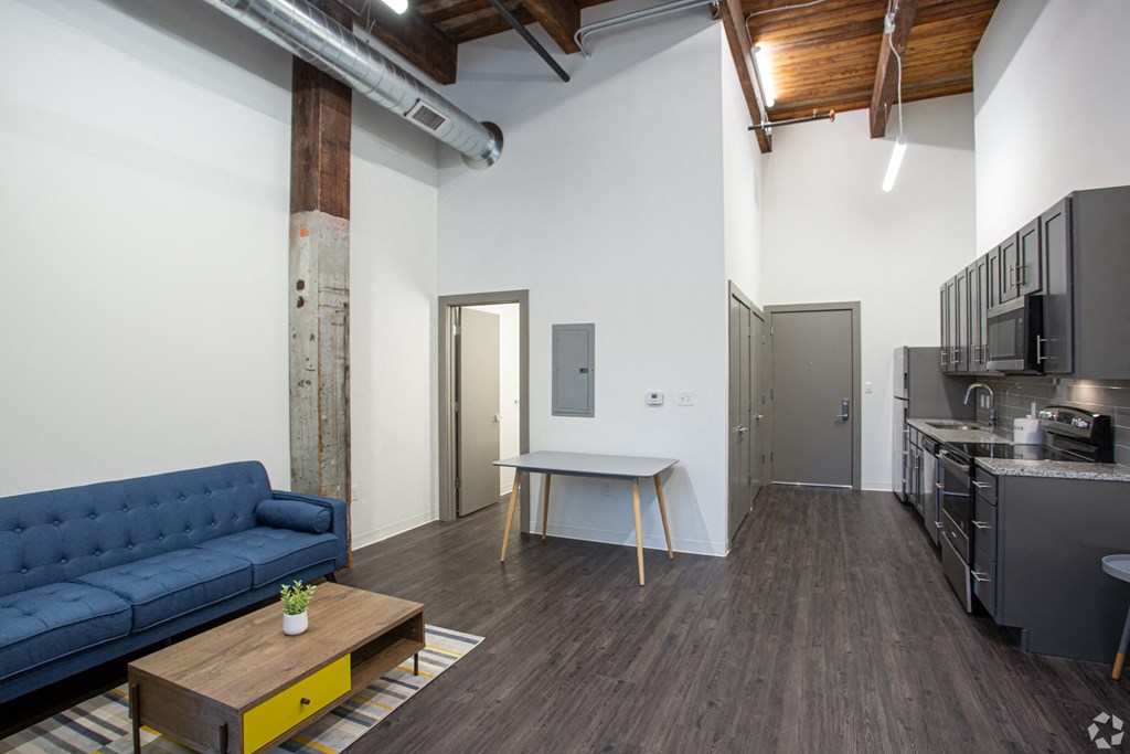 a living room with a blue couch and a kitchen