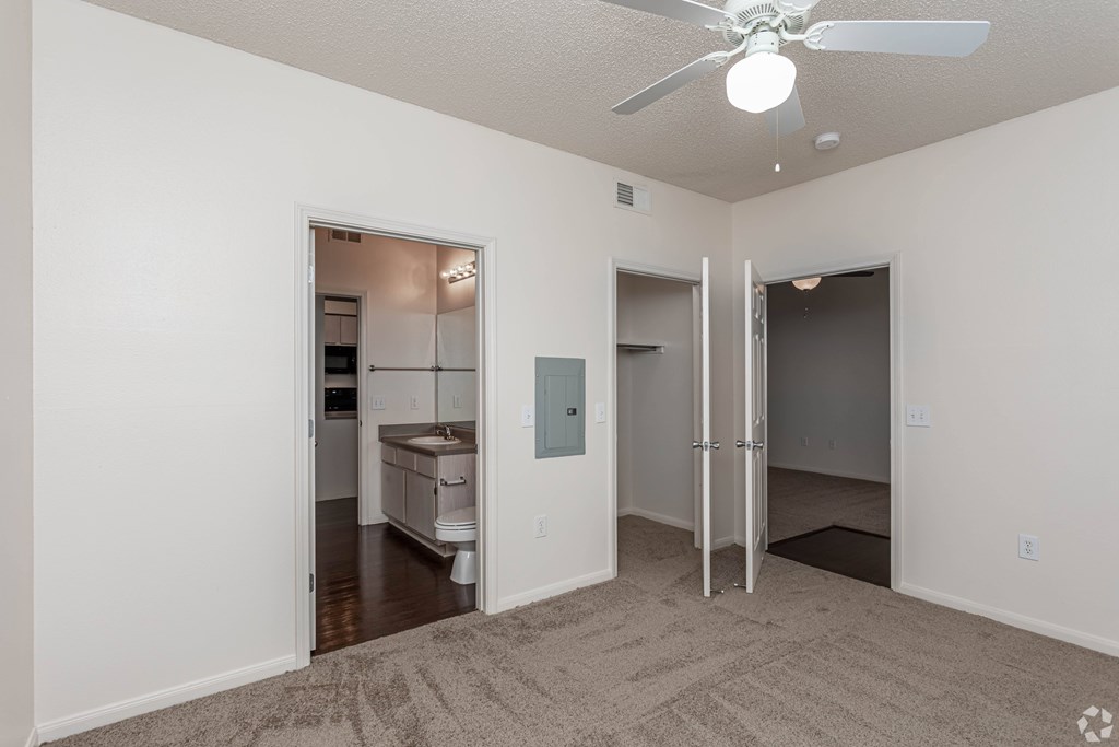 A room with a ceiling fan and a carpeted floor.