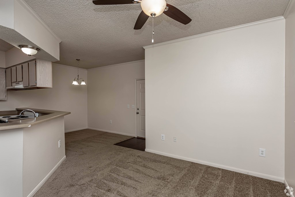 A room with a ceiling fan and a carpeted floor.