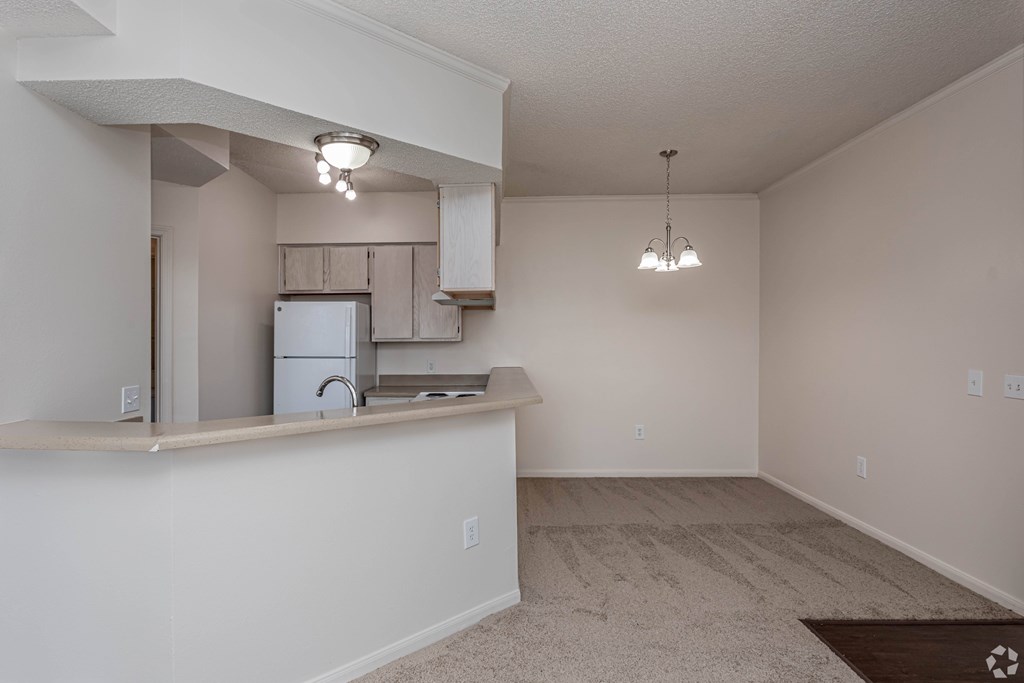A kitchen area with a refrigerator, microwave, and a countertop.