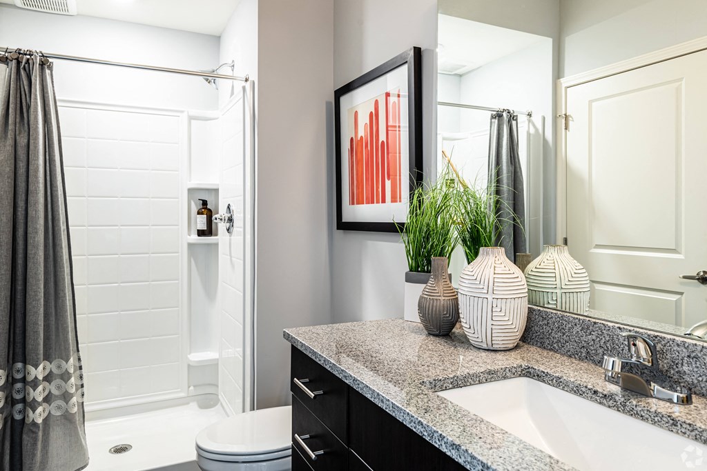 a bathroom with a sink and a shower and a mirror  at Waterside Residences on Quivira, Kansas