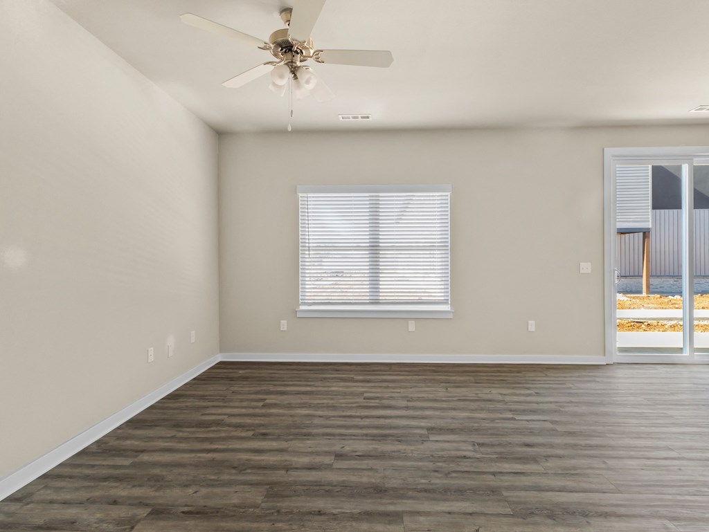 an empty living room with a ceiling fan and a window at Hillcrest Village, Arkansas
