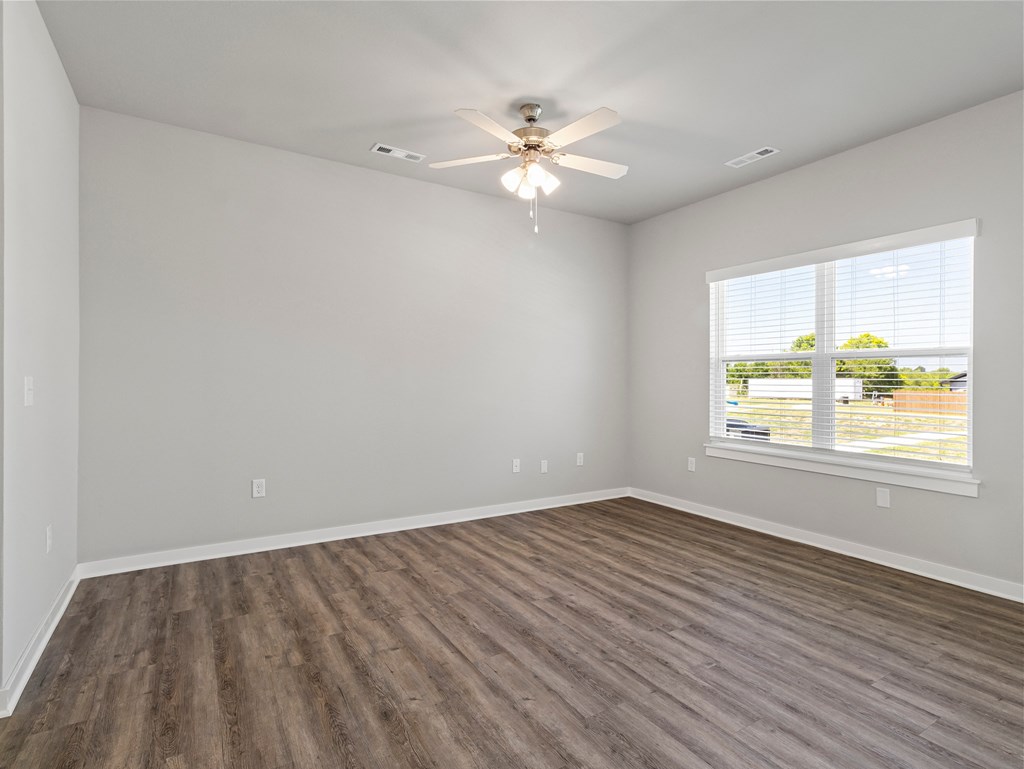 an empty living room with a ceiling fan and a window at Hillcrest Village, Springdale, AR 72762