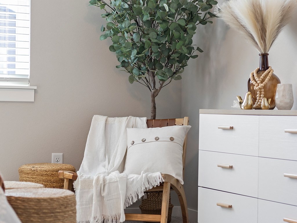 a living room with a chair and a white dresser and a plant at Hillcrest Village, Arkansas