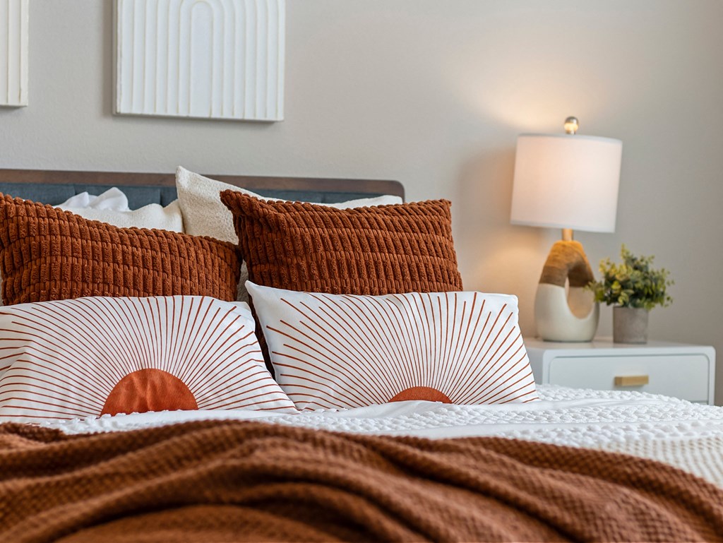 a bed with red and white pillows and a brown blanket at Hillcrest Village, Springdale Arkansas