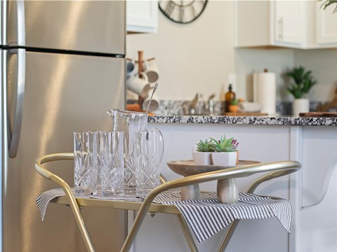 a small kitchen with a table and chairs and a refrigerator
