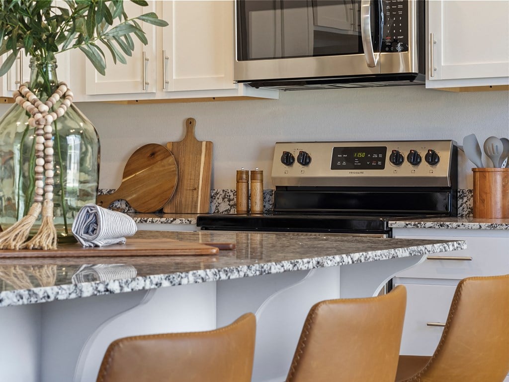 a kitchen with a granite counter top and a microwave at Hillcrest Village, Springdale, 72762