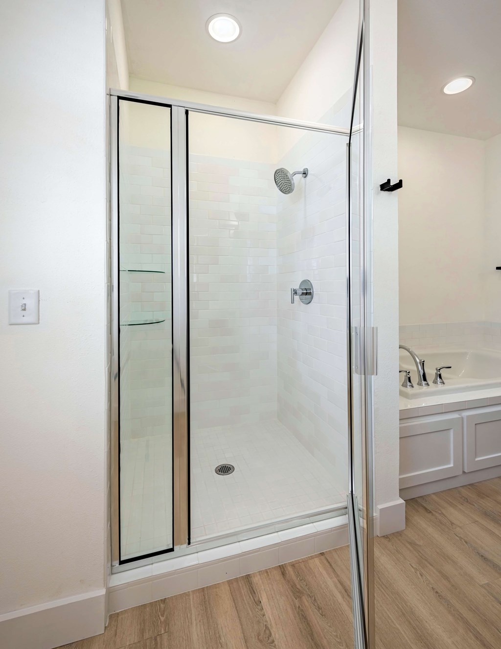 A white bathroom with a glass shower door.