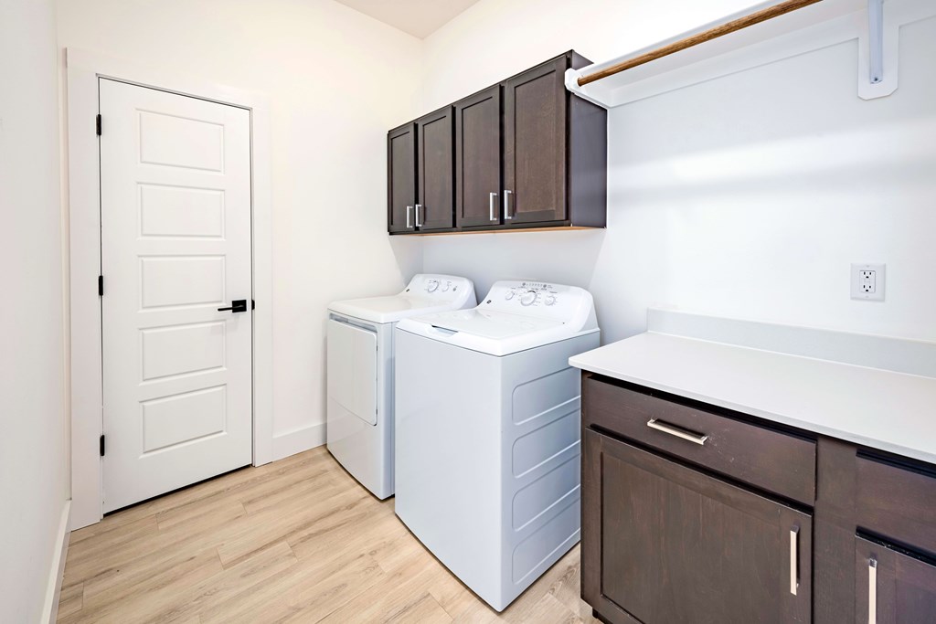 A white door is on the left of a laundry room.