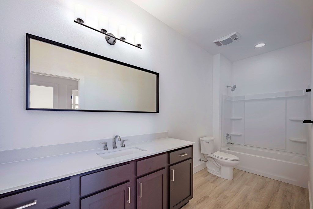 A bathroom with a white sink and purple cabinets.
