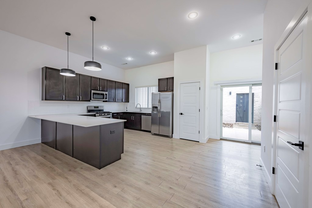 A modern kitchen with dark brown cabinets and a white countertop.