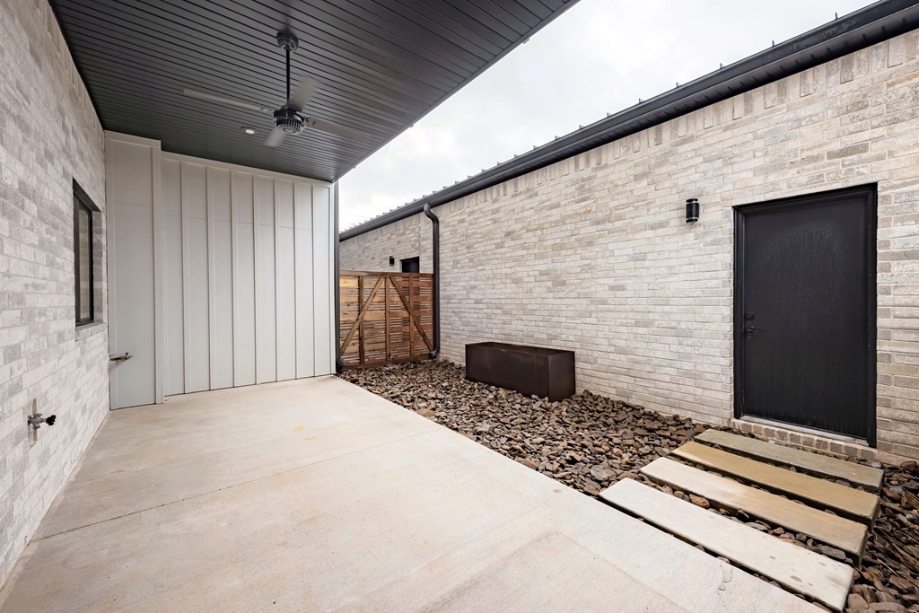 A modern house with a black door and a black ceiling fan.