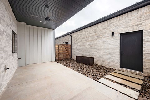 A modern house with a black door and a black ceiling fan.