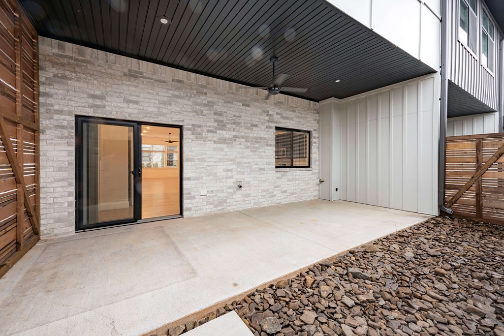 A modern house with a black ceiling fan and a glass door.