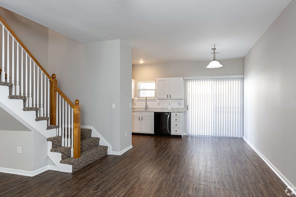 A kitchen with white cabinets and a dishwasher is visible through a window.