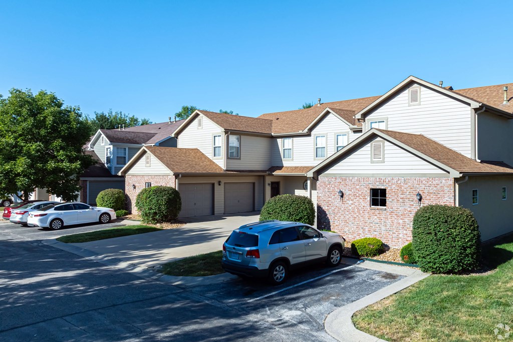 A blue car is parked in front of a house.
