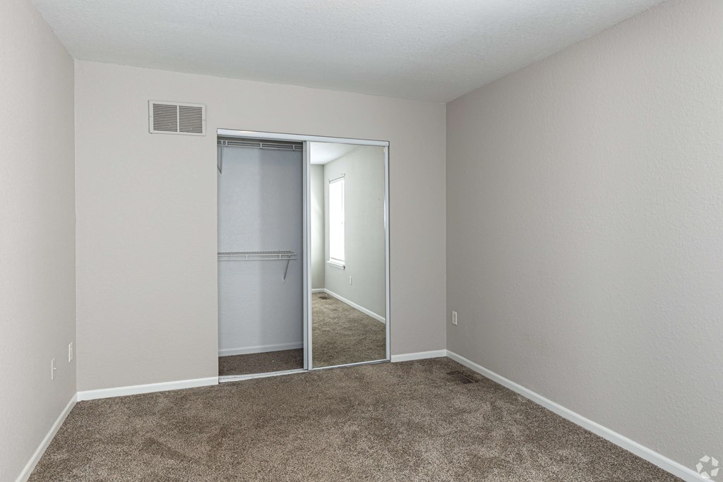A room with a carpeted floor and a sliding glass door.