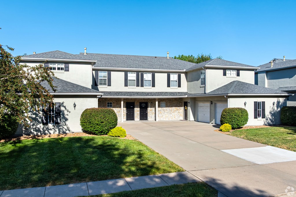 A large, modern house with a grey roof and white walls.
