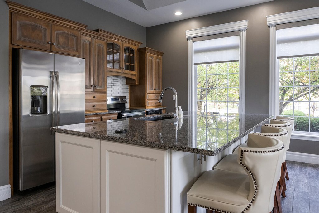 a kitchen with a large island with a granite countertop