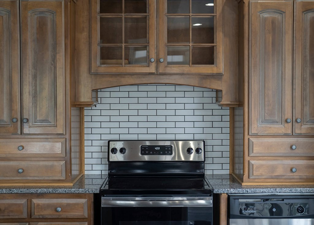 a kitchen with wood cabinets and a black stove top oven