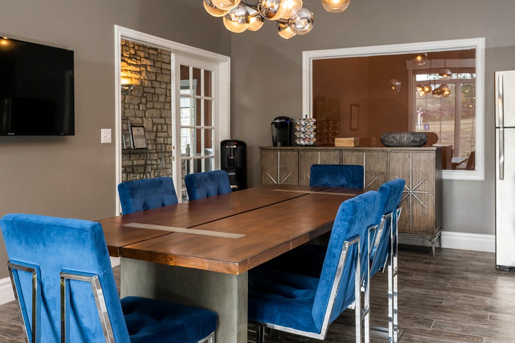a dining room with a long wooden table and blue chairs