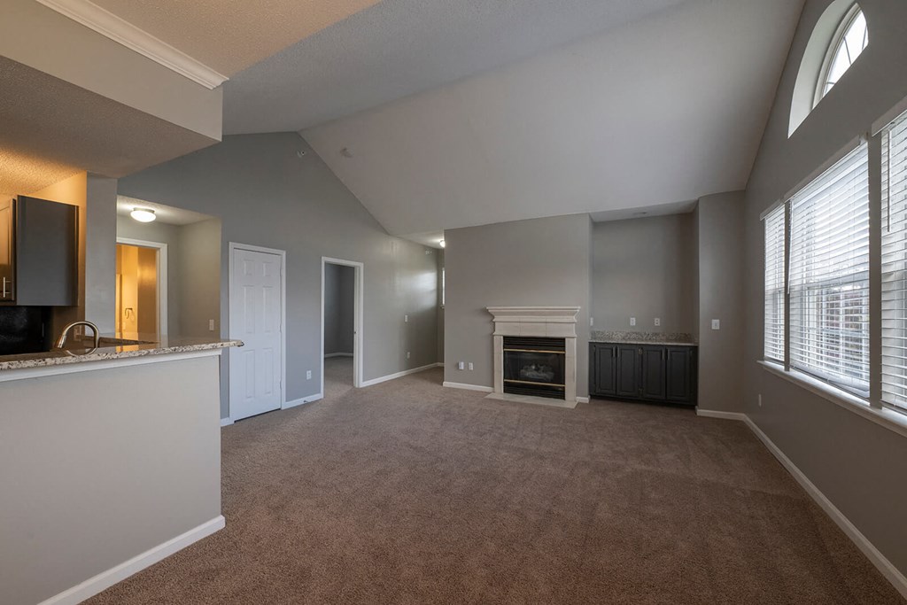 a living room with a fireplace and a kitchen