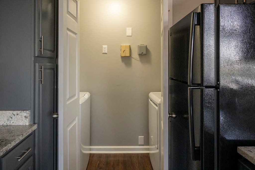 a kitchen with a black refrigerator freezer next to a black and white refrigerator