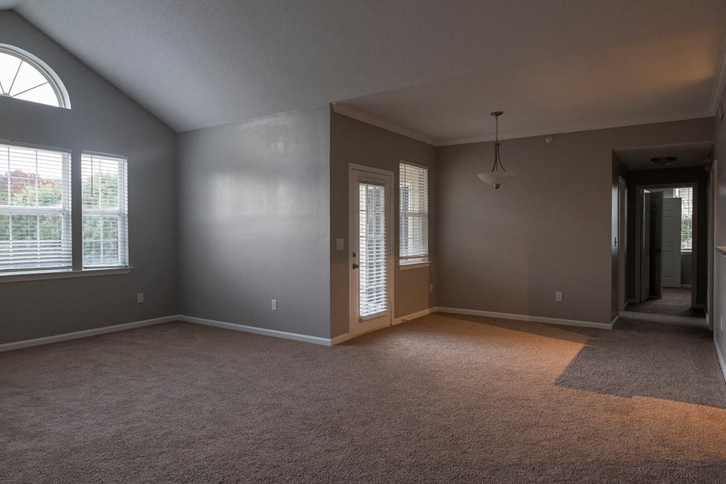 an empty living room with a window and a door