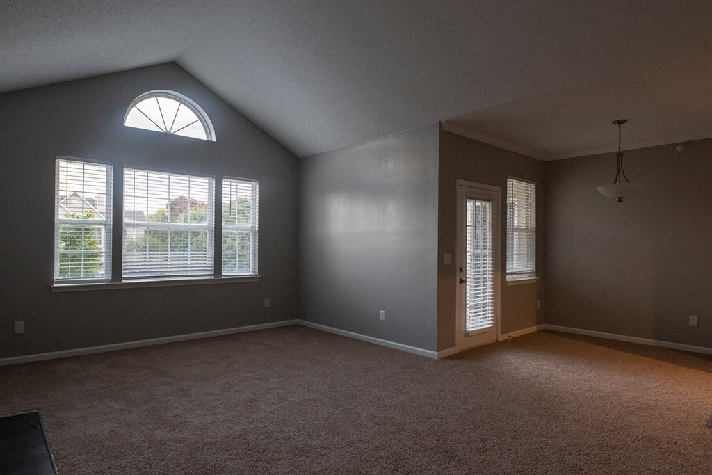 an empty bedroom with a large window and a door