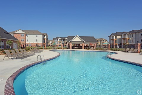 A large swimming pool in front of apartment buildings.