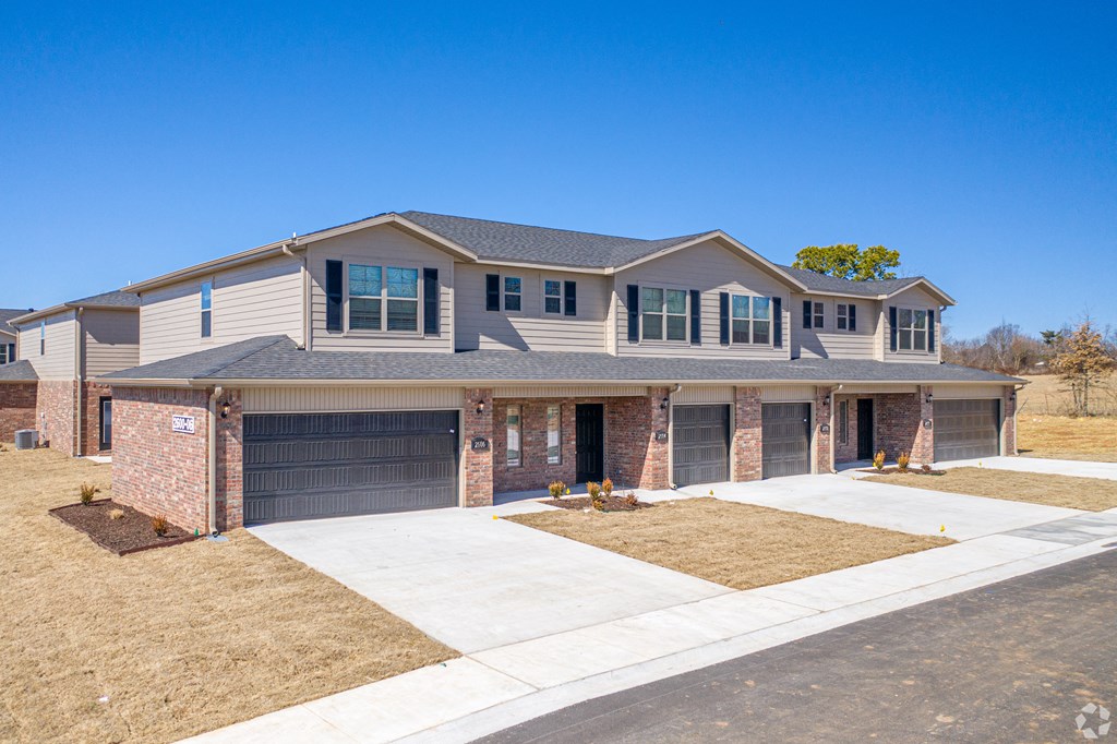 a house with two garages and a sidewalk in front of it