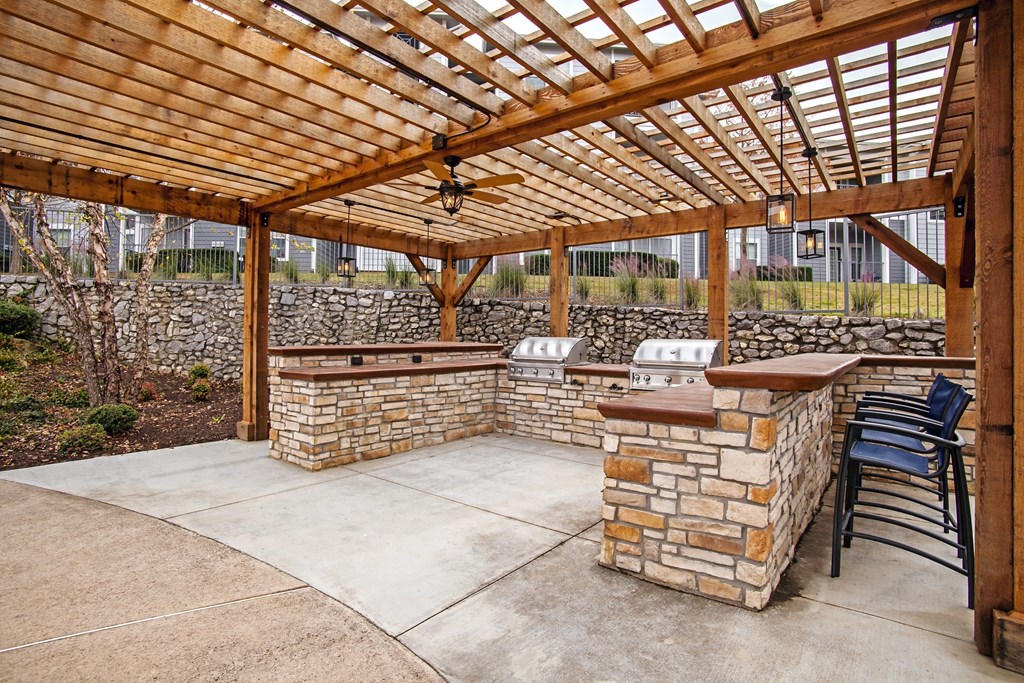 pergola with two outdoor grills and seating