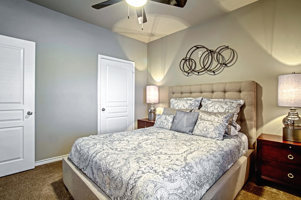 model bedroom with ceiling fan and carpet and queen size bed and walk-in closet